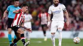 Karim Benzema controla el balón presionado por un jugador del Athletic Club