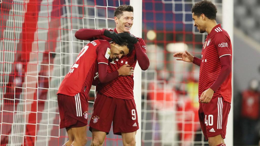 Robert Lewandowski celebra un gol con Jamal Musiala y Malik Tillman.