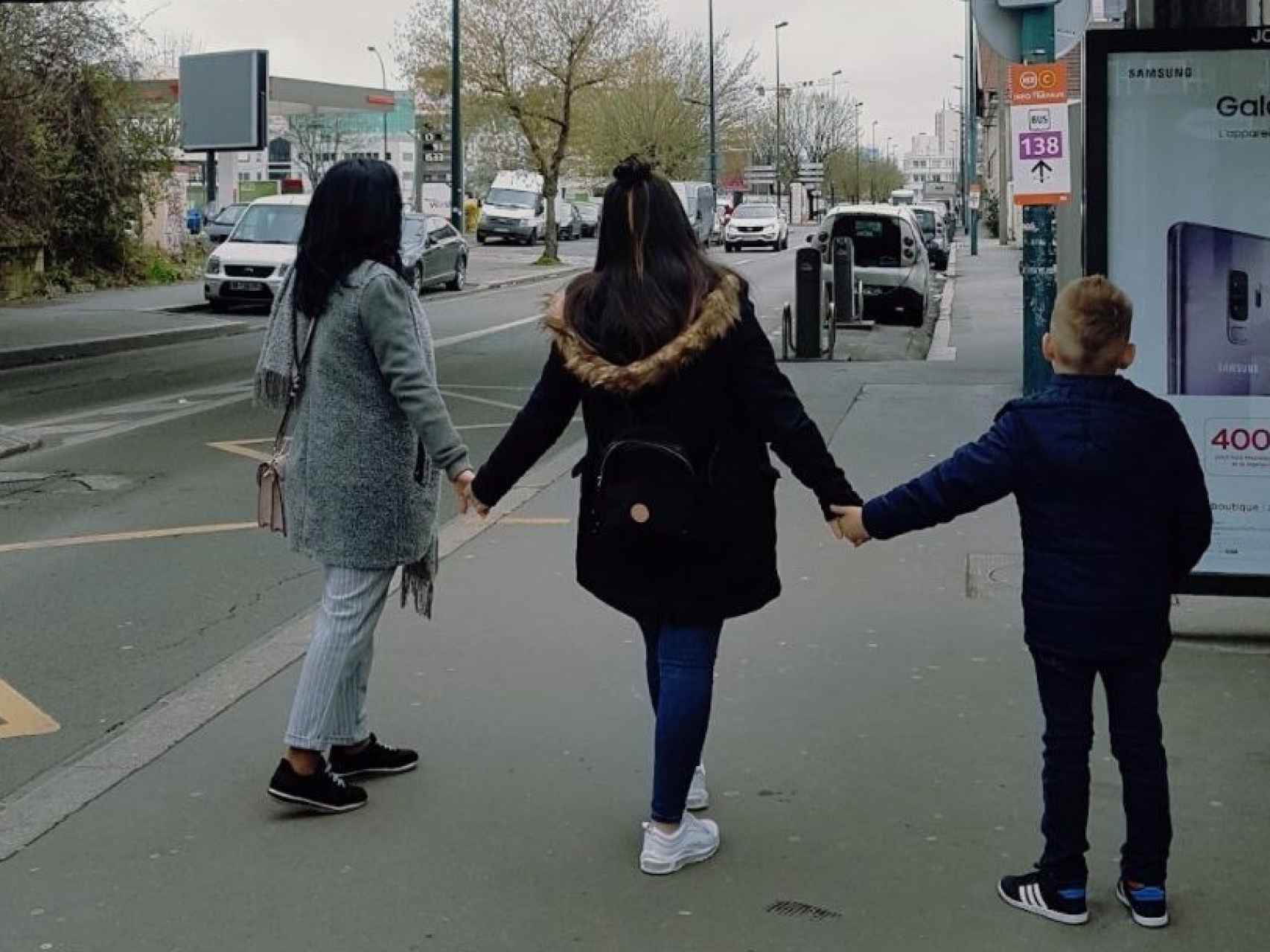 Sara paseando de la mano de sus dos hijos.