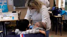 Vacunación en un colegio de la Comunidad Valenciana, con el niño acompañado de su padre, la semana pasada.