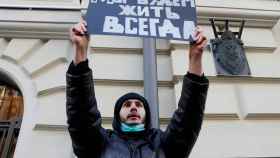 Un simpatizante de Memorial sostiene una pancarta en la que se lee 'Viviremos para siempre' durante una audiencia del Tribunal Supremo ruso en Moscú.