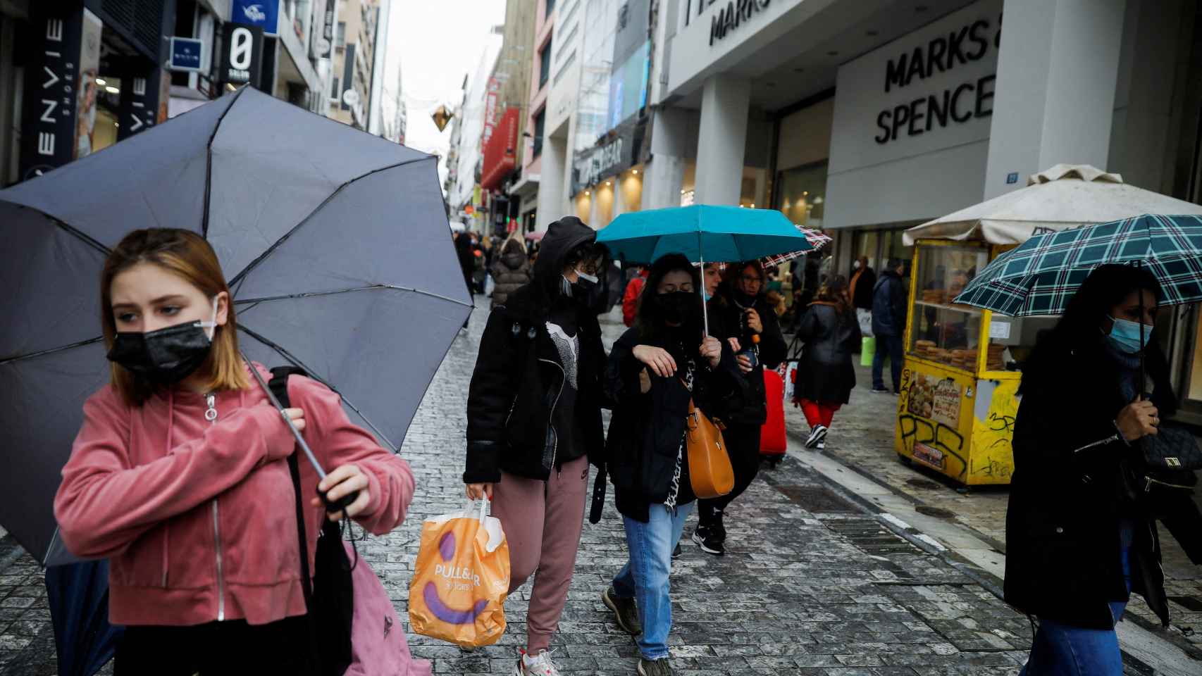 Gente con mascarilla pasea por una de las calles comerciales de Atenas.