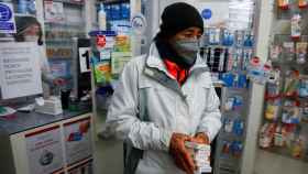 Un ciudadano compra varios test de antígenos en una farmacia.