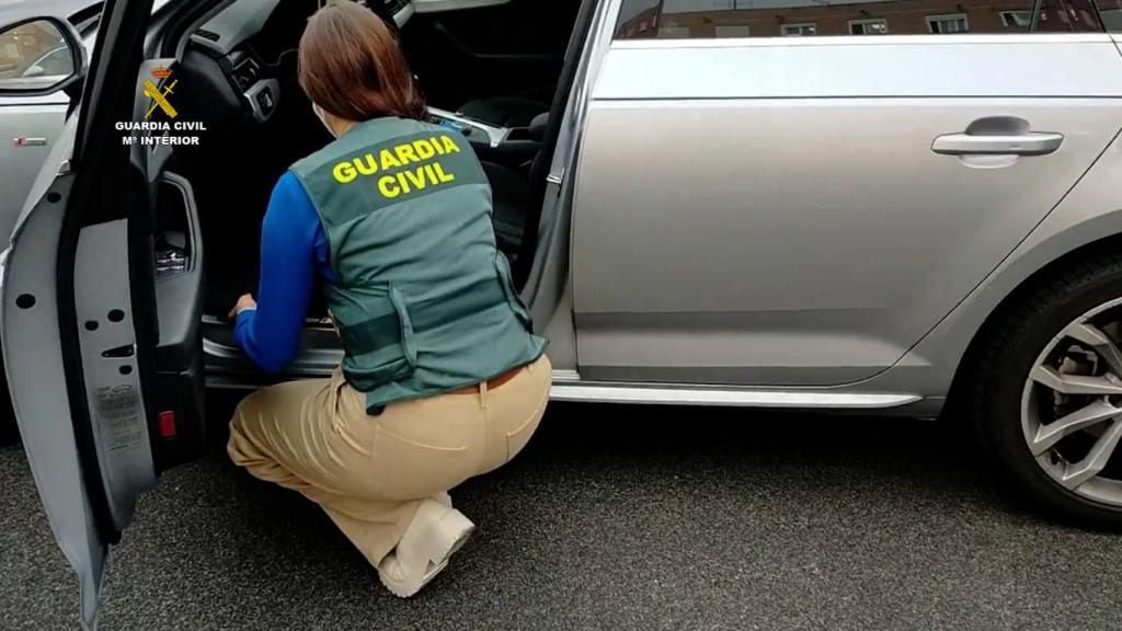Un guardia civil revisa un coche de segunda mano manipulado.