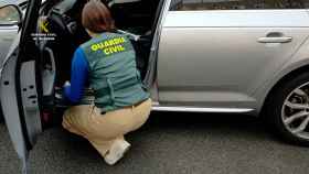 Un guardia civil revisa un coche de segunda mano manipulado.