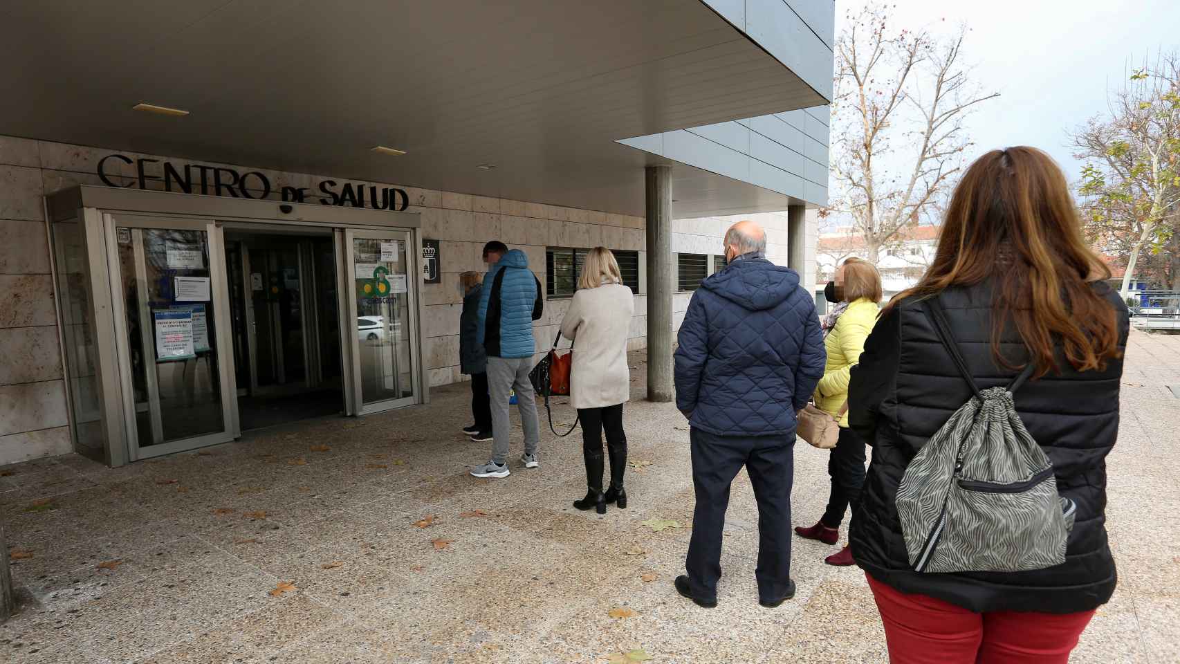 Varias personas esperan para poder acceder a un centro de salud en la ciudad de Toledo.