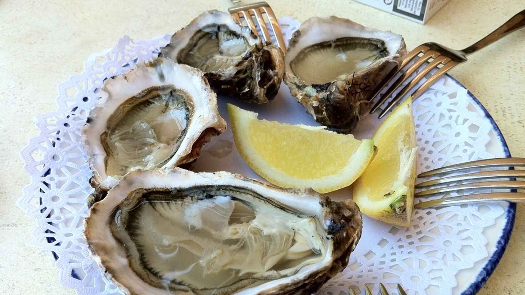 Un plato con ostras y limón.