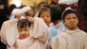 Niños disfrazados de ángeles en una misa en Beijing.