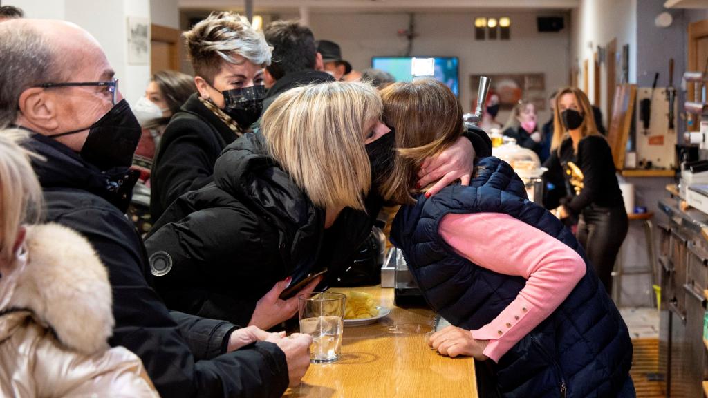 Yolanda Jiménez, en la barra del bar, se abraza con otra vecina ganadora.