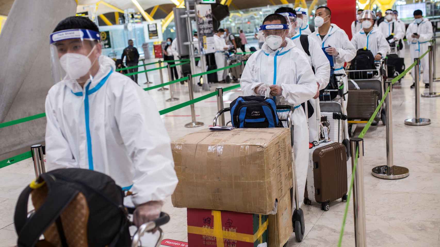 Trabajadores procedentes de China con trajes de protección en la terminal T4 del Aeropuerto Adolfo Suárez Madrid-Barajas, el 21 de mayo de 2021.