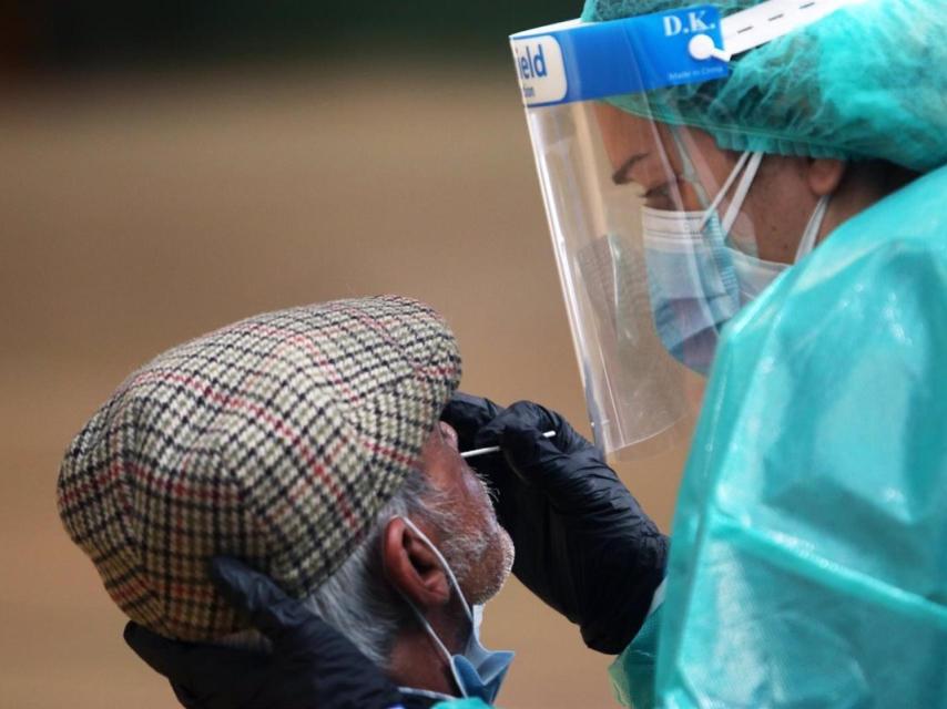 Una sanitaria realiza una prueba PCR a un hombre.