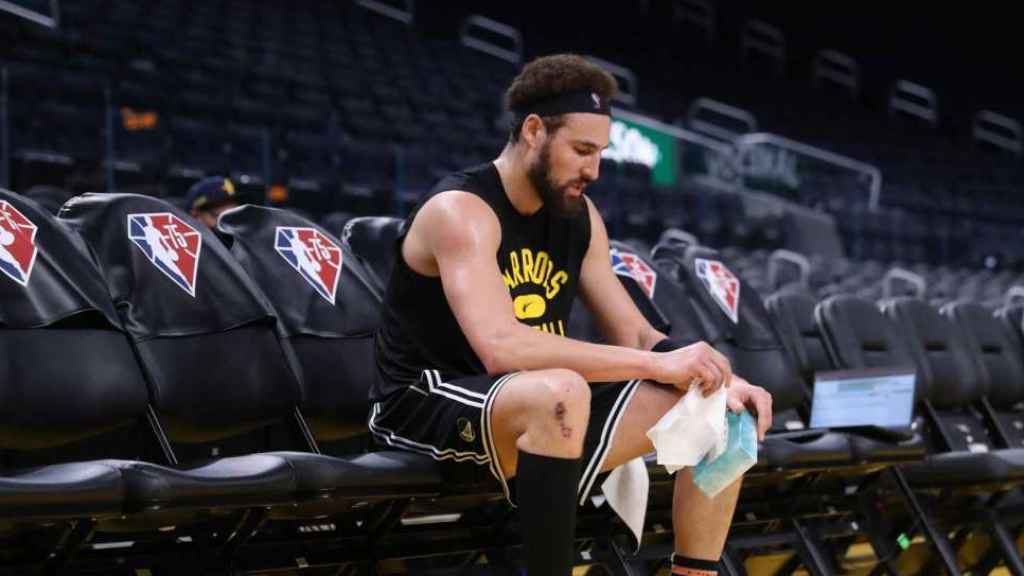 Klay Thompson sentado en la cancha de entrenamiento de los Golden State Warriors