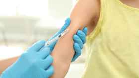 Personal sanitario vacuna a un niño.