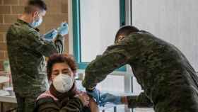 Dos soldados del Ejército de Tierra inoculando la vacuna a una paciente.