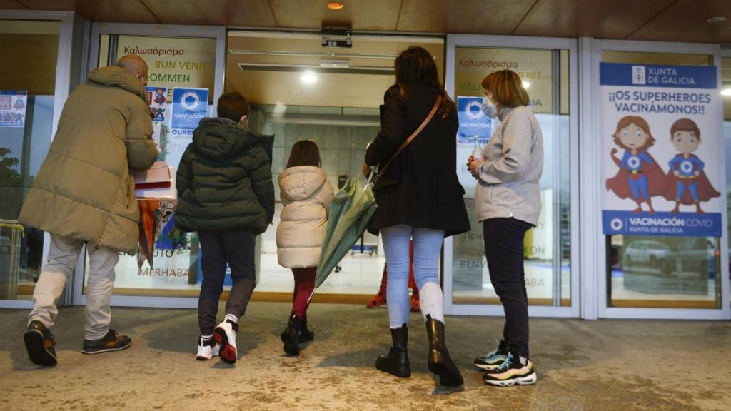 Varios niños acompañados de sus padres, a su llegada al recinto ferial Expourense para ser vacunados contra la Covid-19.