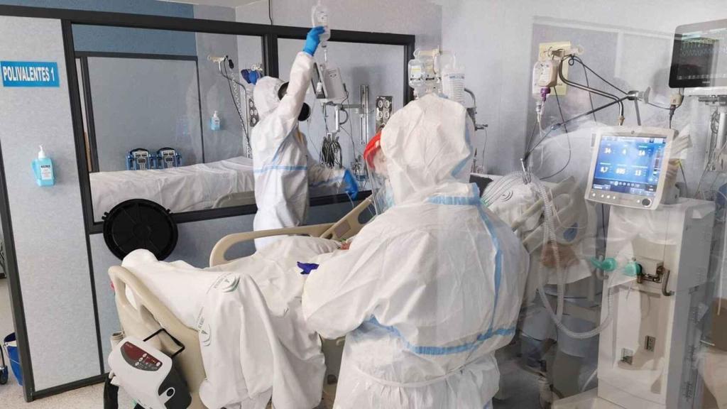 Dos sanitarios atienden a una persona hospitalizada con coronavirus.