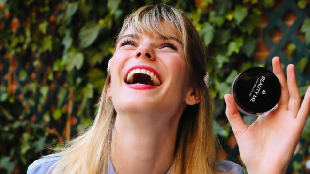 Una chica posa con un producto cosmético.