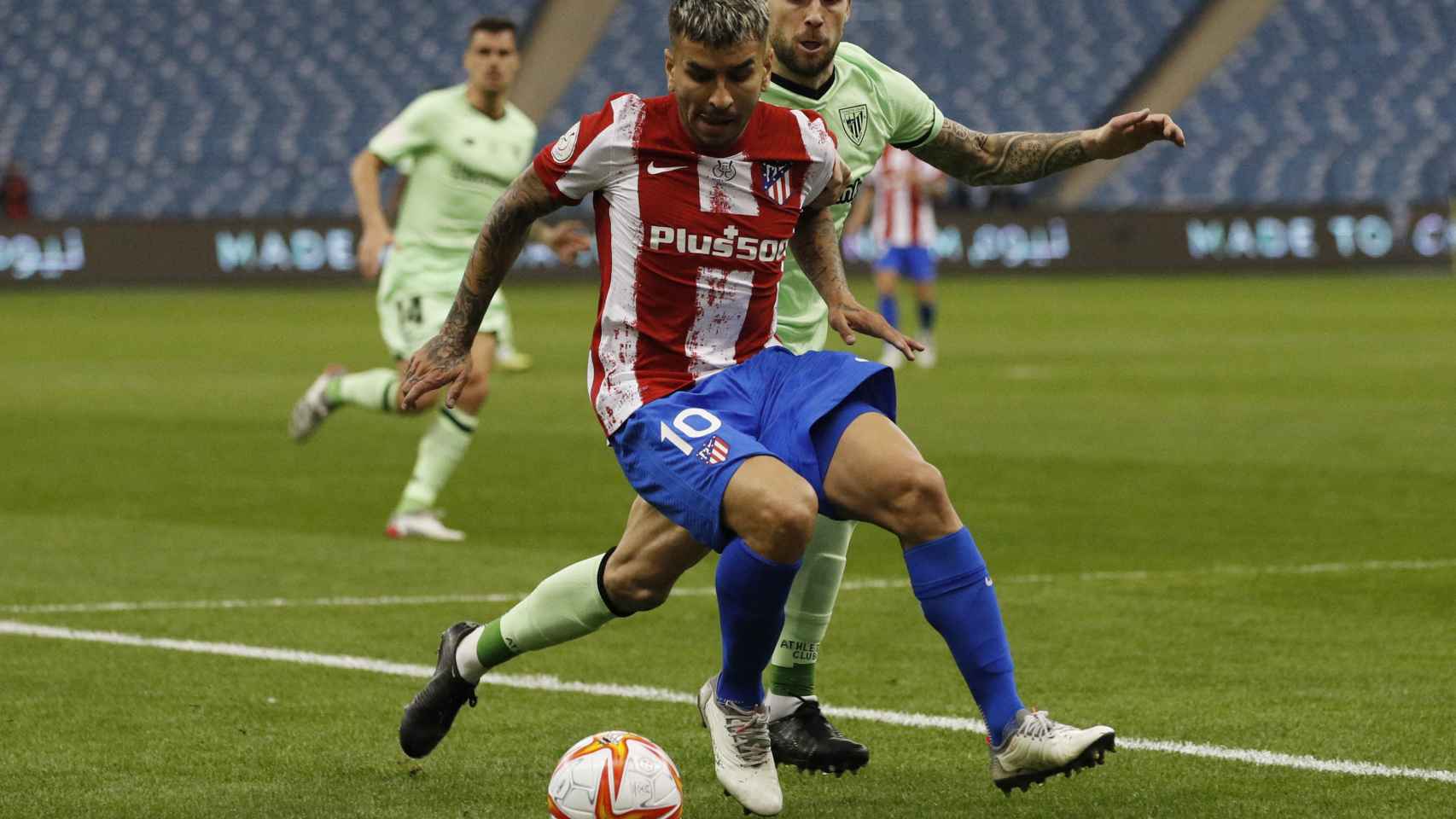 Ángel Correa protege el balón ante Iñigo Martínez, en la Supercopa de España 2022