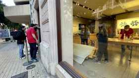 Los operarios retiran los restos de cristal del interior de la tienda Apple de Valencia.