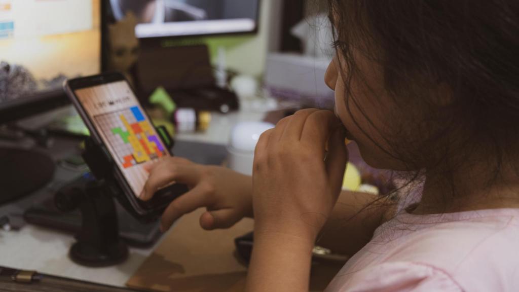 Una niña interactúa con una aplicación en un teléfono móvil.