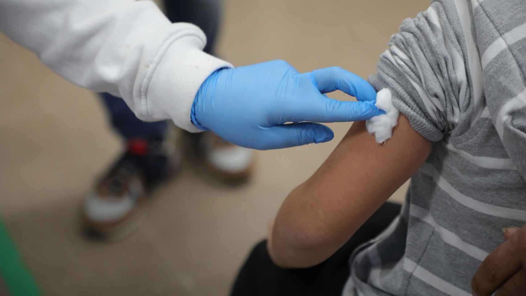 Un sanitario vacuna a un niño.