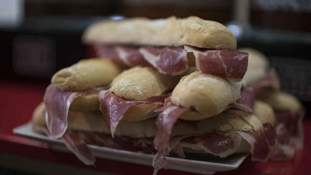 Varios bocadillos de jamón ibérico amontonados.