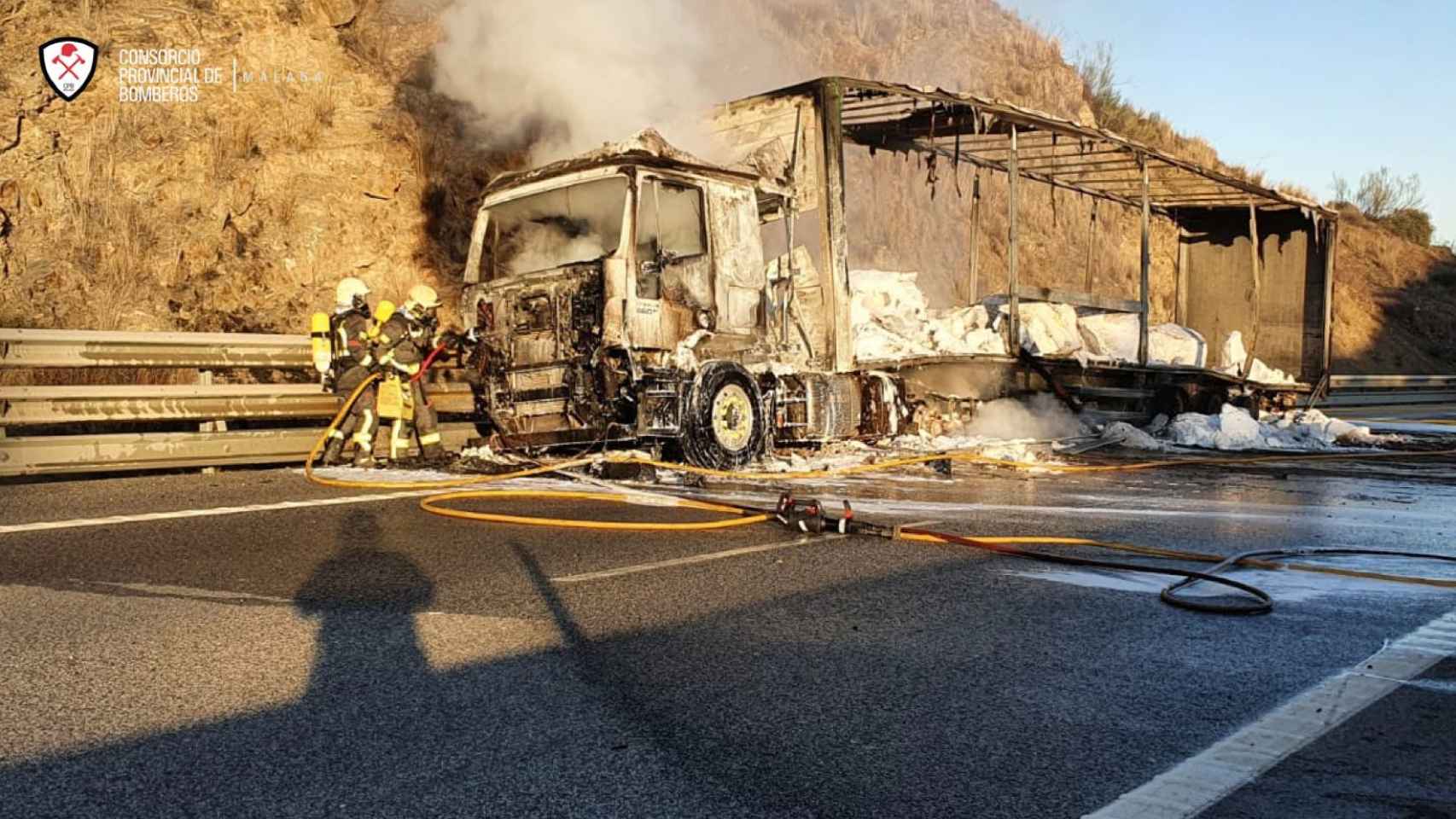 Varios bomberos participan en la extinción fuego que ha afectado a un camión cargado de nitrato potásico.