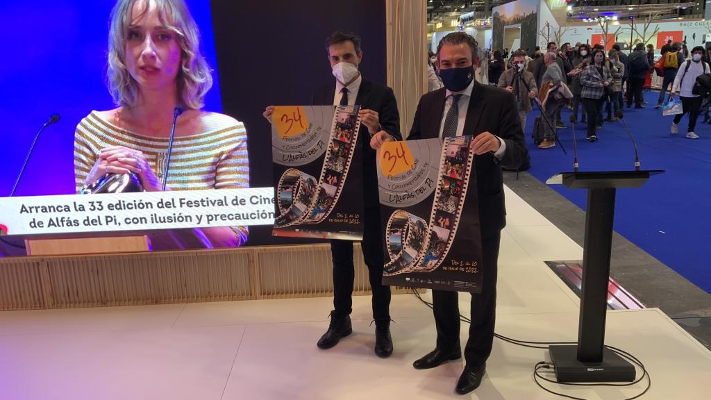 El alcalde de L'Alfàs y el director del Festival de Cine, con el cartel en el stand de Costa Blanca.