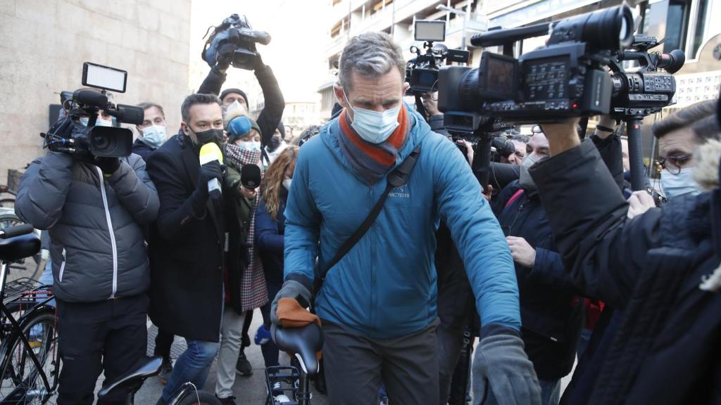 El exduque de Palma, rodeado de medios de comunicación, montándose en su bicicleta tras terminar su jornada laboral.