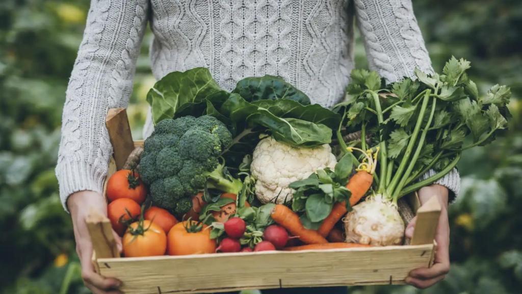 Un cajón de madera con verduras.