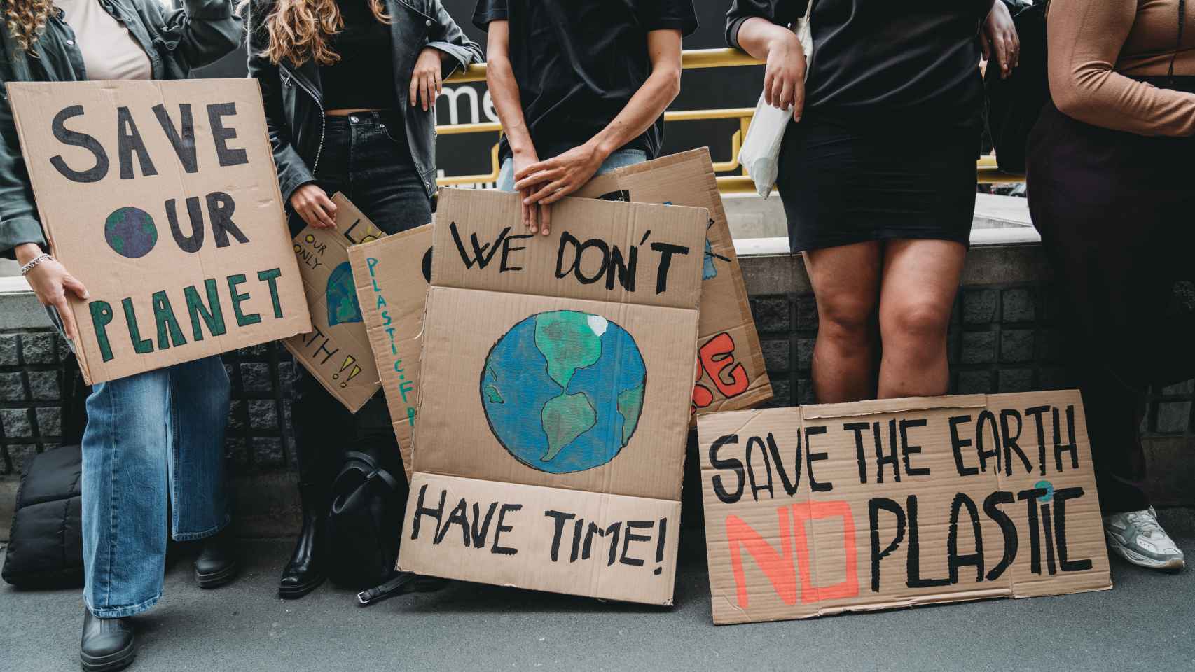 Un grupo de jóvenes sostiene pancartas mientras van a una manifestación contra el cambio climático