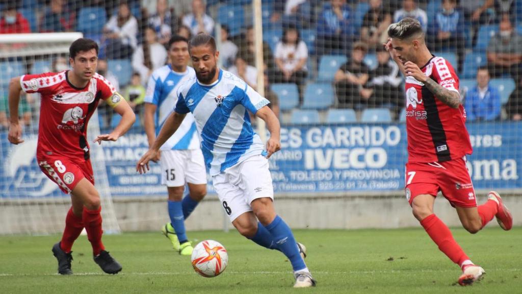 Borja conduce el balón ante dos rivales.