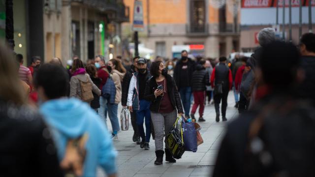 Viandantes tras realizar compras de Navidad.