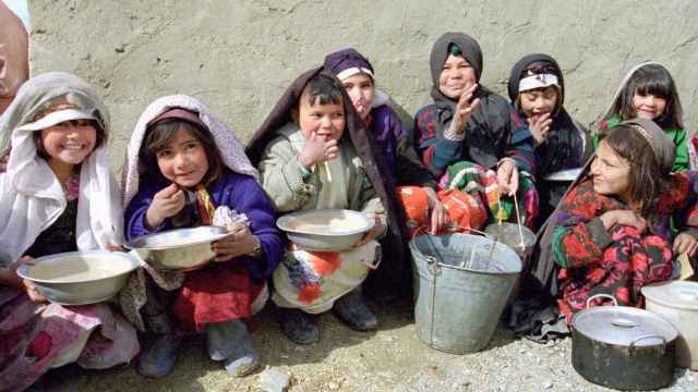 Un grupo de niños afganos reciben alimentos del programa de Naciones Unidas en el campamento de desplazados cerca de Herat.