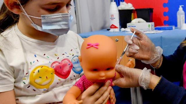 Una enfermera finge vacunar también a la muñeca de una niña para tranquilizarla en Nápoles, Italia. Ciro Fusco