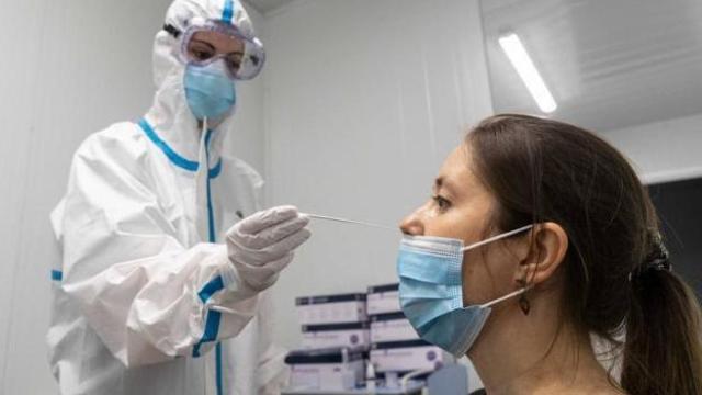 Una sanitaria realiza una prueba PCR a una joven.