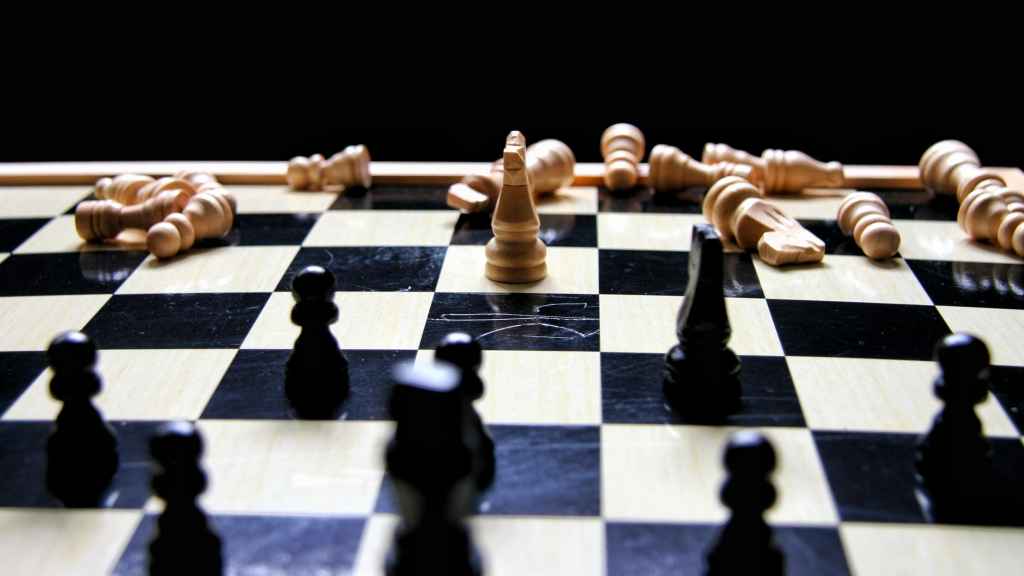 Un tablero de ajedrez con casi todas las piezas blancas caídas.