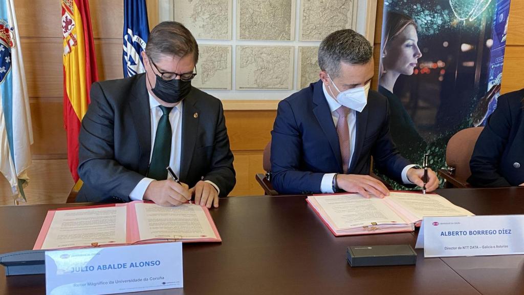 El rector de la UDC, Julio Abalde, y el director de las oficinas de Galicia y Asturias de NTT DATA, Alberto Borrego, firman el convenio de colaboración.