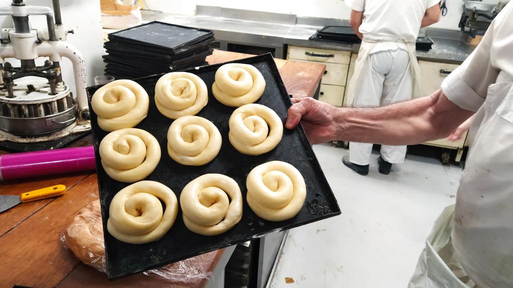 Uno de los reposteros muestra una bandeja de las ensaimadas de Formentor antes de ser horneadas.