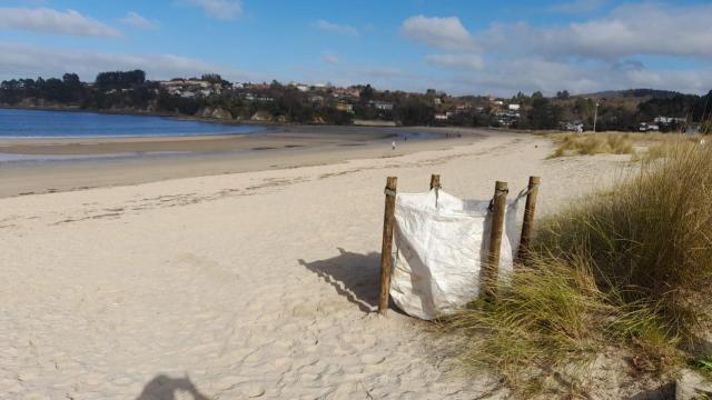 Bolsas para la recogida de basura en la playa de Miño
