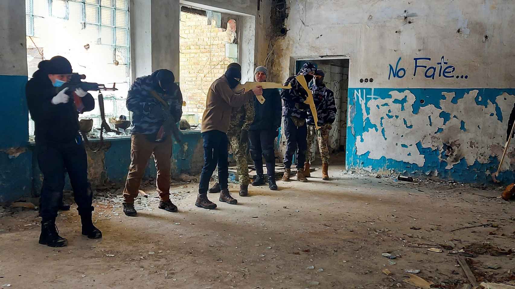 Civiles ucranianos armados con fusiles de madera juegan a la guerra en las ruinas de una antigua fábrica de Kiev.
