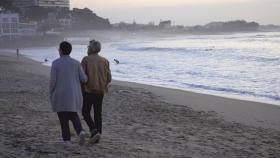 Una pareja pasea por la playa de Samil en Vigo.