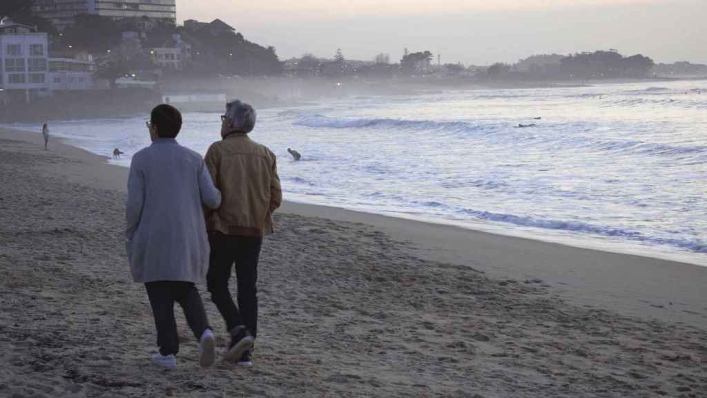 Una pareja pasea por la playa de Samil en Vigo.