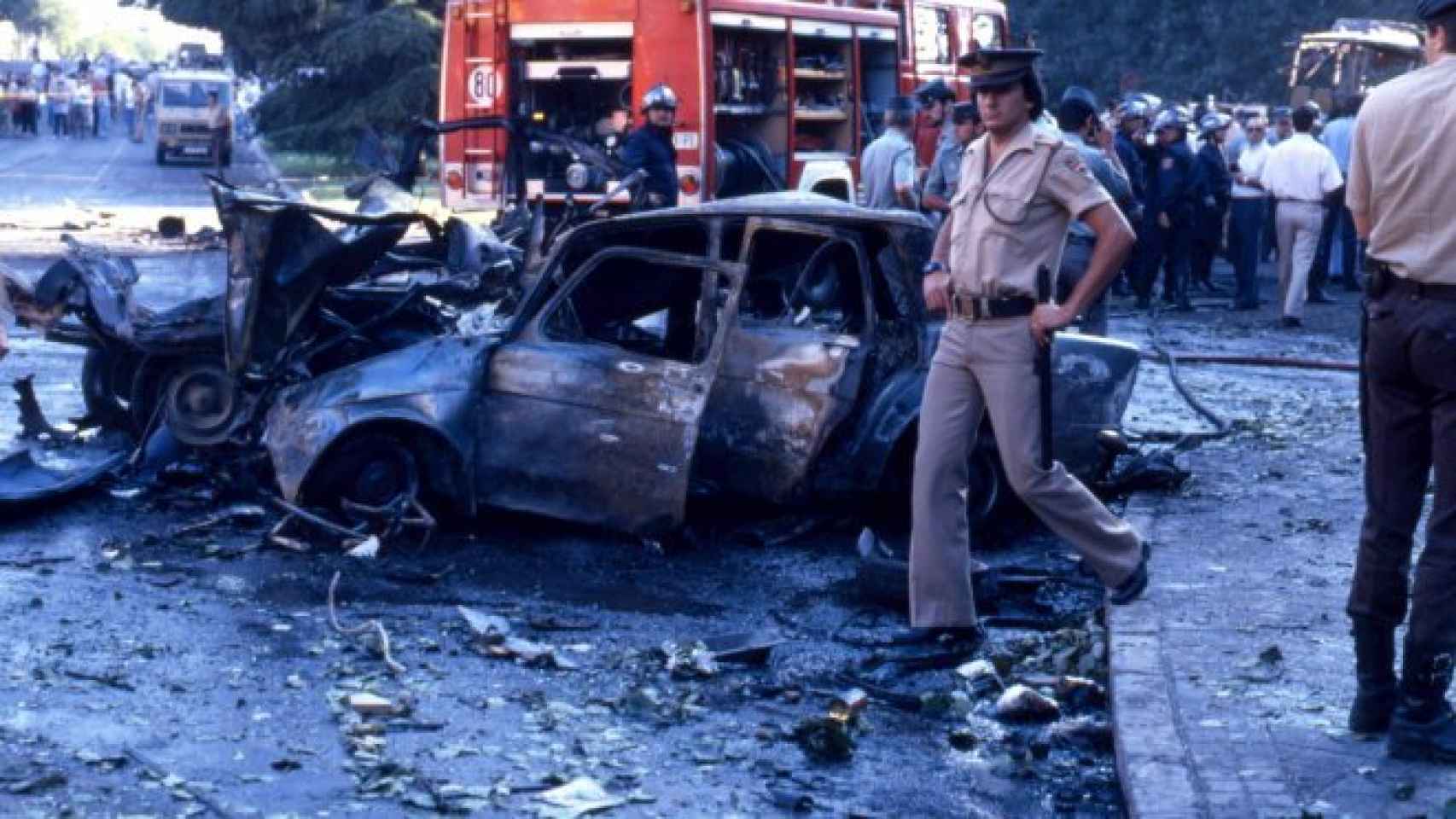 Un policía ante los restos del coche bomba del atentado de en la Plaza de la República Dominicana de Madrid, a 14 de julio de 1986.
