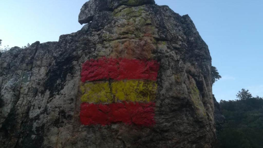 Dibujo de la bandera pintada encima de las pinturas rupestres.