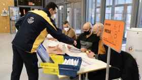 Un empleado entrega el voto por correo en una mesa electoral en las elecciones autonómicas de Castilla y León.
