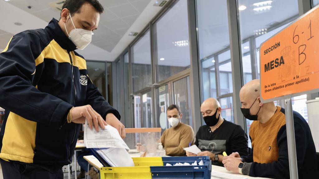 Un empleado entrega el voto por correo en una mesa electoral en las elecciones de Castilla y León