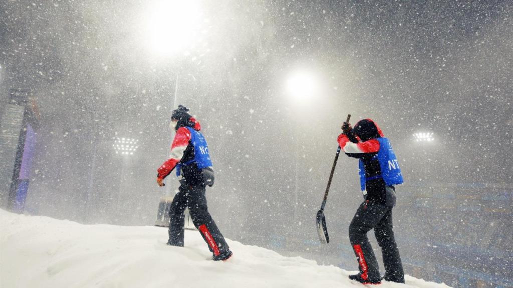 Trabajadores de los Juegos Olímpicos de Invierno de Pekín 2022 quitando nieve