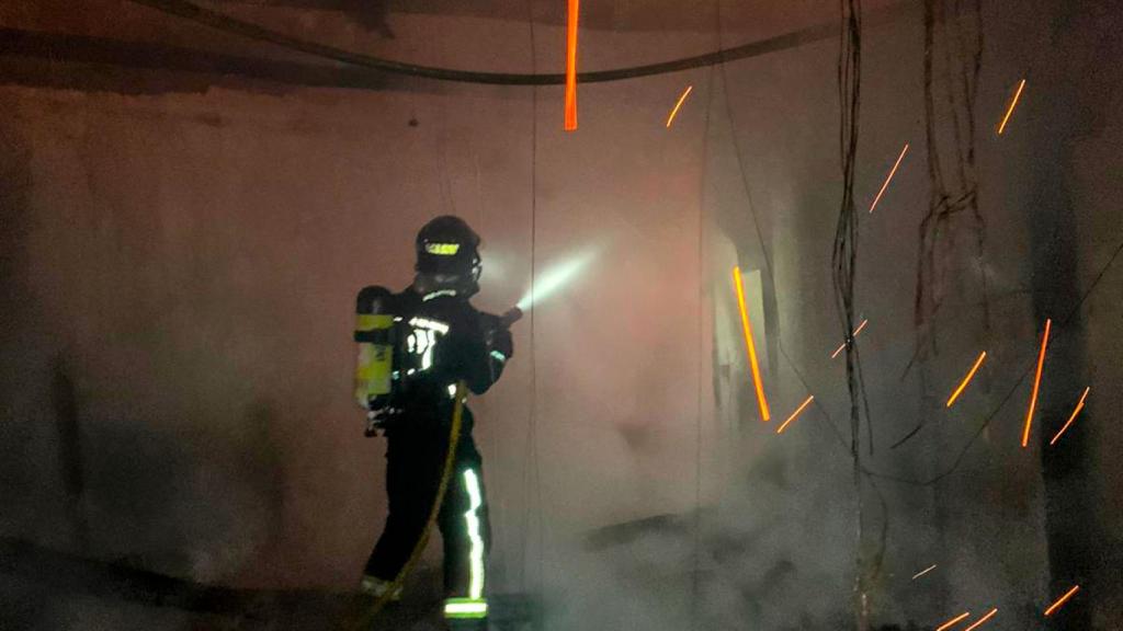 Uno de los bomberos trata de sofocar el incendio