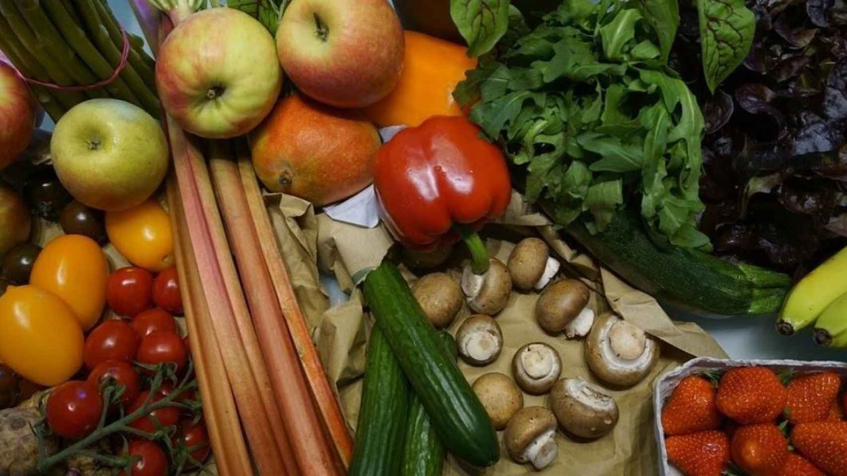 Una cesta de la compra con frutas, verduras y hortalizas.